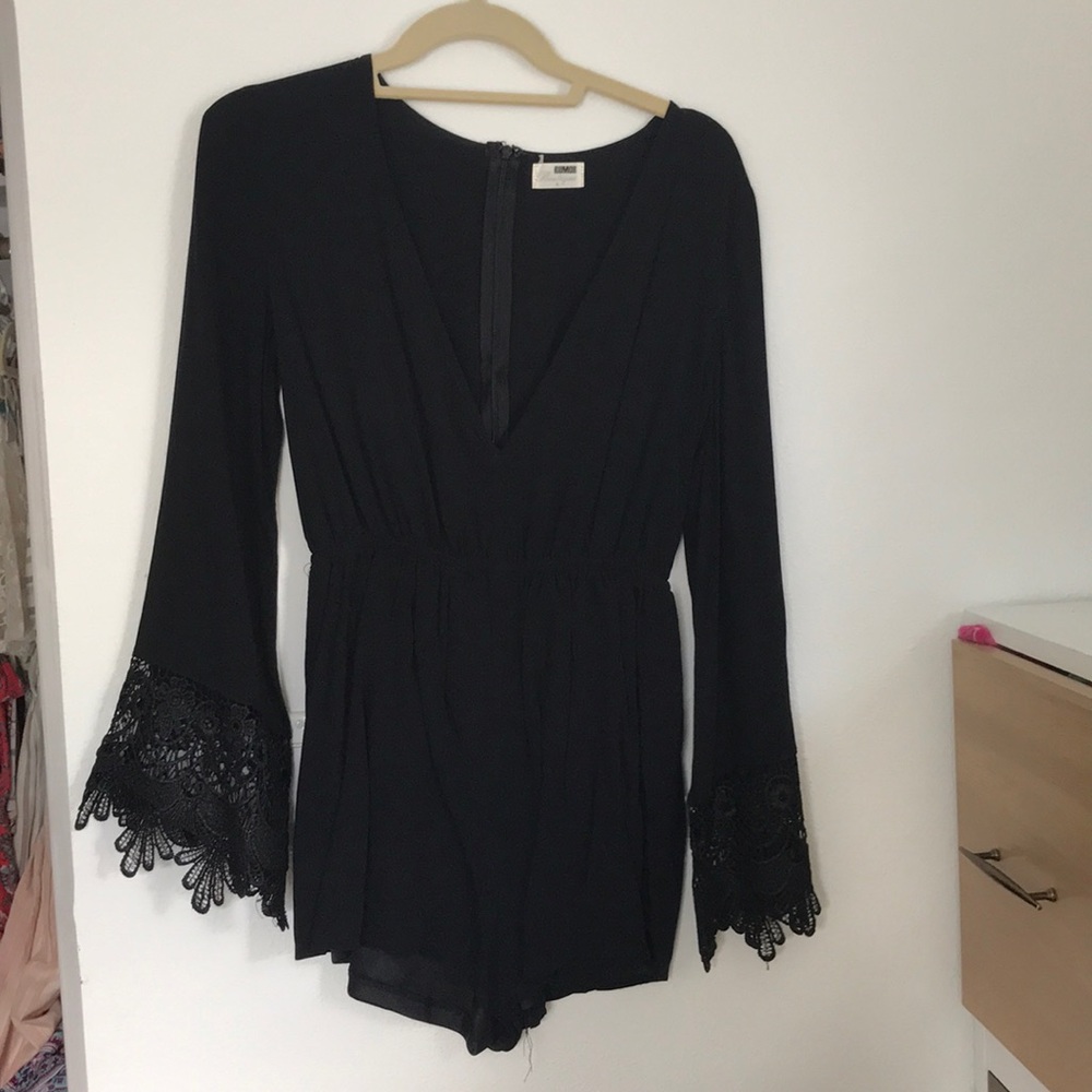 Black romper with lace bell sleeves.